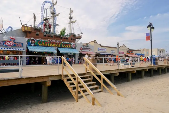 The Ocean City boardwalk with Playland’s Castaway Cove pirate ship and shops above the beach stairs
